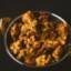 Delicious Indian pakoda served in a traditional metal bowl, showcasing vibrant flavors and texture.